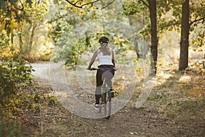 Woman rides a trail in the park. Active lifestyle, morning ride. Film Grain