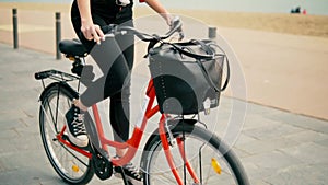 Woman riding bicycle along beach sand at summer time