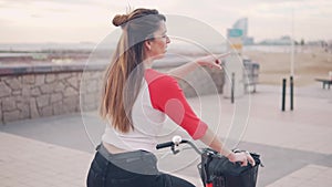 Woman riding bicycle along beach sand at summer time