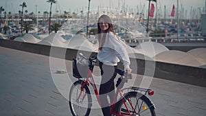 Woman riding bicycle along beach at summer time