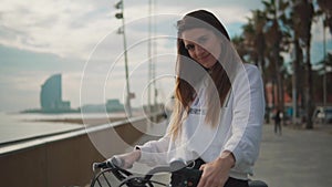 Woman riding bicycle along beach at summer time