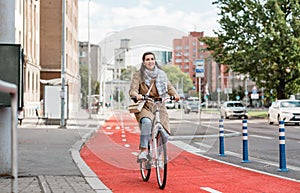 woman riding bicycle along red bike lane in city