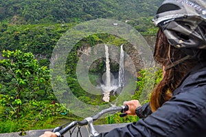 Woman riding bicycle at Banos, Ecuador