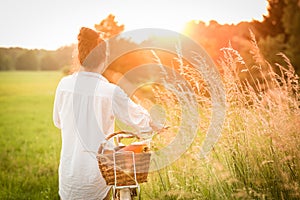 Woman riding bicycle with the basket of fresh food.