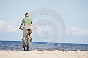 Woman riding bicycle in beach