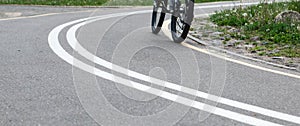 Woman riding a bike on bike path with markings in park