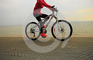 Woman riding bike on seaside