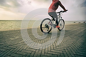 Woman riding bike on seaside