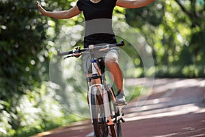 Woman riding a bike on sunny park trail