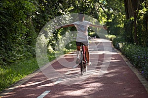 Woman riding a bike on sunny park trail