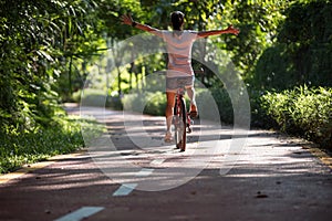 Woman riding a bike on sunny park trail