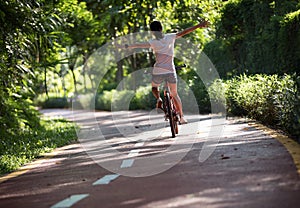 Woman riding a bike on sunny park trail