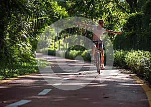 Woman riding a bike on sunny park trail