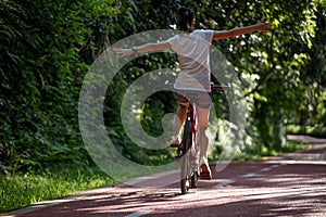 Woman riding a bike on sunny park trail