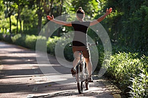 Woman riding a bike on sunny park trail