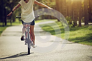 Woman riding a bike on sunny park trail