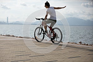 woman riding a bike on sunny seaside