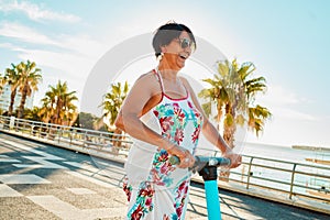 Woman riding electric scooter, happy retirement and summer ride at tropical island beach resort for vacation. City photo
