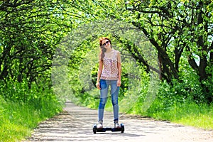 Woman riding an electrical scooter outdoors - hover board, smart balance wheel, gyro scooter, hyroscooter, personal Eco transport photo