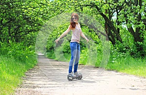 Woman riding an electrical scooter outdoors - hover board, smart balance wheel, gyro scooter, hyroscooter, personal Eco transport photo
