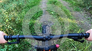 Woman riding a fat tire bike on muddy trail in the nature in summer, reversed