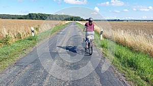 woman riding her bike on lonesome rural road