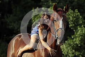 Woman riding horse bareback through forest