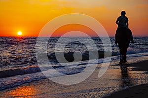 Woman riding a horse on the beach