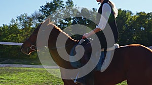 A woman is riding a horse at an outdoor manege