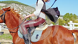 A woman is riding a horse at an outdoor manege