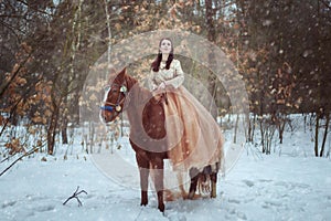 Woman riding a horse in the winter forest