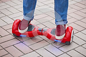 Woman riding on modern red electric mini segway or hover board scooter