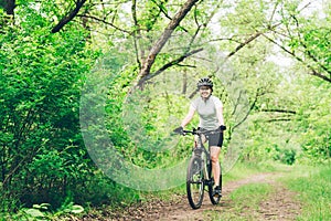 Woman riding a mountain bike in the forest