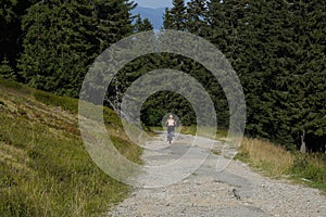 Woman riding a mountain bike on a land road.