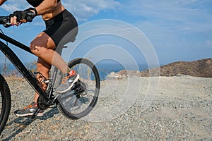 Woman riding a mountain bike on the mountain. ocean in the background