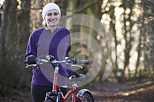 Woman Riding Mountain Bike Through Woodlands photo