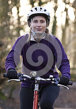 Woman Riding Mountain Bike Through Woodlands photo