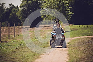 Woman riding quad atv vehicle running on dirt field