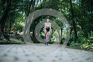 Woman riding a road bike. Portrait of young beautiful woman on pink bike