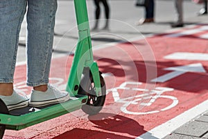 woman riding scooter along bike lane road in city