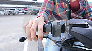 A woman is riding a scooter in a parking lot