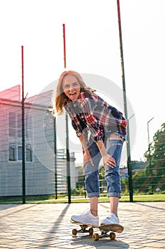 Woman riding a skateboard on street. Skater girl on a longboard. Cool female skateboarder at sunset. Carefree female