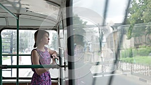 Woman riding in a trolley and looking in window