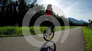 Woman riding unicycle on road 4k