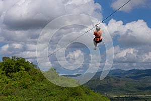 Woman riding in zip line in the Valley of Sugar Mills in Trinidad Cuba