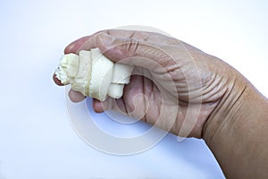 Woman right hand holding Dog bone, Ate Dog treats, Rawhide dog chews on white background, Close up shot, Snack for dog