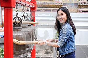 Woman ringing a bell in a Buddhist temple