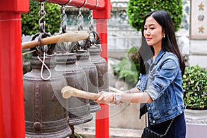 Woman ringing a bell in a Buddhist temple