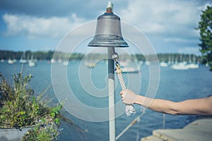 Woman ringing bell to call boatman