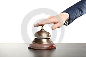 Woman ringing hotel service bell at grey table